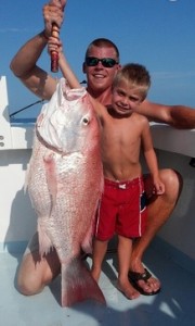 Kid holding fish caught on family fishing trip.on the Finest Kind Charter Boat in Destin, FL.